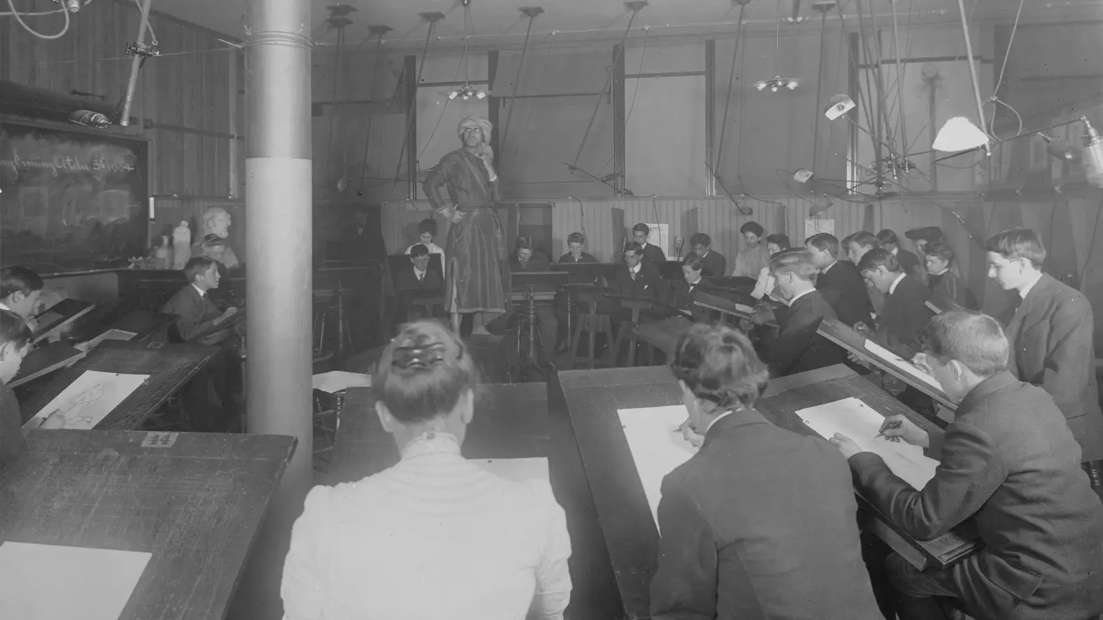 a group of men sitting at desks in a room
