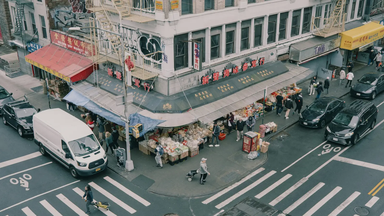 Busy street corner with market stalls and traffic